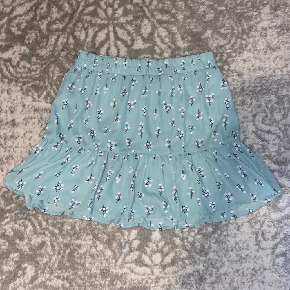 Teal colored skirt with flower pattern.